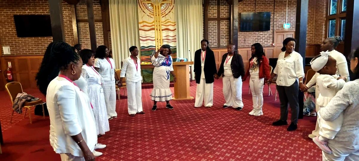 Women joining hands in a prayer circle