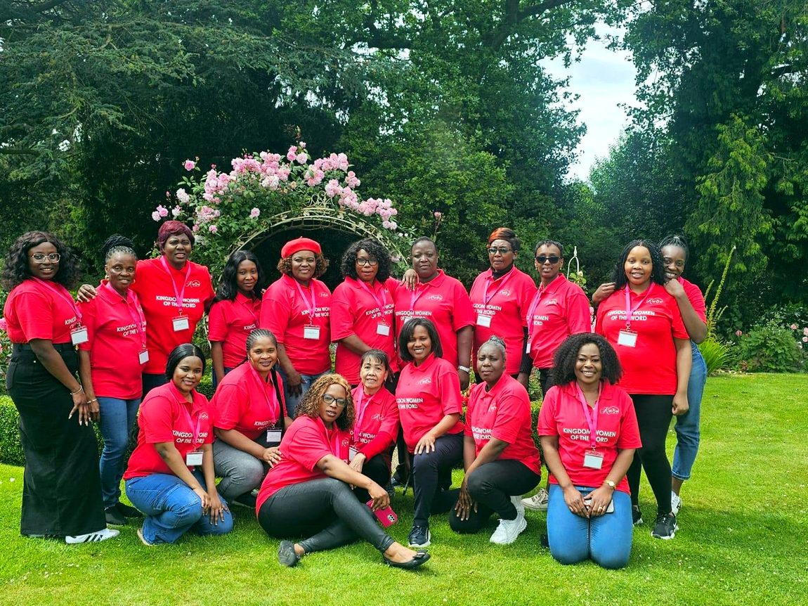 Joyful Kingdom Women of the Word together beneath a rose arch in the gardens of their retreat